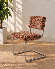 Load image into Gallery viewer, Modern 70s-style dining chair with terracotta and black tiger-print upholstery and polished chrome cantilever frame