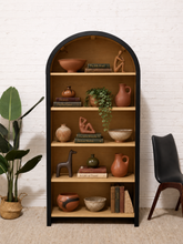 Load image into Gallery viewer, Tall arched bookcase with black outer frame, warm natural wood interior, and five open display shelves.