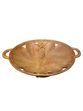 Load image into Gallery viewer, A carved wooden Swiss Black Forest bowl with two side handles and a raised floral design on the interior, photographed on a dark surface against a black background.