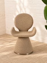 Load image into Gallery viewer, Adler fully upholstered sand dining chair with rounded back, curved wraparound seat, pedestal base, and brushed brass accent.