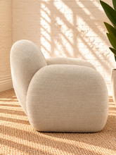 Load image into Gallery viewer, Adriana ivory chenille accent chair with rounded wraparound back, curved upholstered arms, plush seat cushion, and sculptural silhouette.