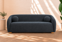 Load image into Gallery viewer, Amara slate navy curved sofa with textured upholstery, rounded arms, ball accent pillows, and wood bun feet