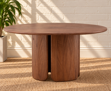Load image into Gallery viewer, Amari round dining table in natural brown Mindi wood with sculptural rounded column pedestal base and visible wood grain.