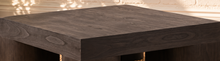 Load image into Gallery viewer, Arnold square coffee table in natural dark brown mindi wood veneer with a thick tabletop and sculptural curved supports.
