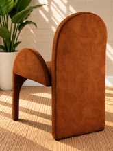 Load image into Gallery viewer, Bailey upholstered dining chair in Burnt Cognac velvet with curved arms and sculptural contemporary frame