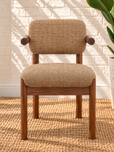 Load image into Gallery viewer, Caroline dining chair upholstered in toffee brown burlap fabric with curved wraparound back, rounded arms, and Mindi wood legs.