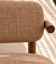 Load image into Gallery viewer, Caroline dining chair upholstered in toffee brown burlap fabric with curved wraparound back, rounded arms, and Mindi wood legs.