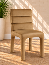 Load image into Gallery viewer, Shop the Conrad Dining Chair in Honey Cognac, featuring luxurious velvet upholstery, a deep channel-tufted back, and a sculptural contemporary silhouette.