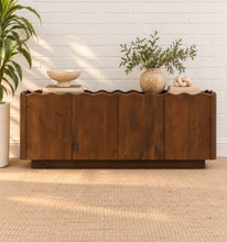 Load image into Gallery viewer, Eden natural brown mango wood credenza with sculptural wave-edged detailing, paneled cabinet doors, concealed shelving, and recessed plinth base.