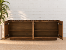 Load image into Gallery viewer, Eden natural brown mango wood credenza with sculptural wave-edged detailing, paneled cabinet doors, concealed shelving, and recessed plinth base.