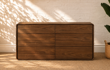 Load image into Gallery viewer, Finley six-drawer dresser in warm walnut with natural wood grain, rounded corner frame and handle-free push-to-open drawer fronts.
