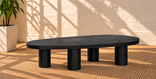 Load image into Gallery viewer, Henry solid oak coffee table in Natural Black with organic rounded tabletop, four cylindrical legs, and visible natural oak grain.