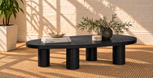 Load image into Gallery viewer, Henry solid oak coffee table in Natural Black with organic rounded tabletop, four cylindrical legs, and visible natural oak grain.