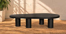 Load image into Gallery viewer, Henry solid oak coffee table in Natural Black with organic rounded tabletop, four cylindrical legs, and visible natural oak grain.