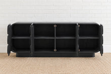 Load image into Gallery viewer, Jaylen charcoal mindi wood credenza with four cabinet doors, raised circular geometric details, rounded corners, and interior shelving.