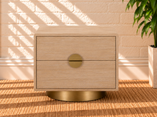 Load image into Gallery viewer, Jimena blonde oak two-drawer nightstand with brushed brass metal base and circular handle.