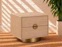 Load image into Gallery viewer, Jimena blonde oak two-drawer nightstand with brushed brass metal base and circular handle.