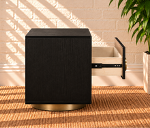 Load image into Gallery viewer, Jimena charcoal two-drawer nightstand with oak veneer, brushed brass circular handle, and rounded brass metal base.
