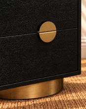 Load image into Gallery viewer, Jimena charcoal two-drawer nightstand with oak veneer, brushed brass circular handle, and rounded brass metal base.