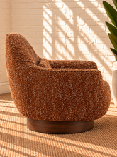 Load image into Gallery viewer, Katiana rust chunky bouclé swivel accent chair with rounded back, curved arms, cushioned seat, and dark rubber wood base.
