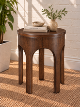 Load image into Gallery viewer, Kaylee sculptural side table in natural brown with a round top and arched Art Deco-inspired base.