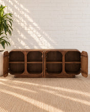 Load image into Gallery viewer, Keanu natural brown mindi wood credenza with four rounded cabinet doors, curved corners, low plinth base, and interior shelving.
