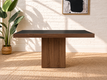 Load image into Gallery viewer, Kenji square dining table with inset black tempered glass top, walnut wood veneer border, and substantial square pedestal base.