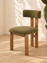 Load image into Gallery viewer, Kiki dining chair with avocado green bouclé upholstered seat and backrest, high-density foam cushioning and natural solid ash wood frame.