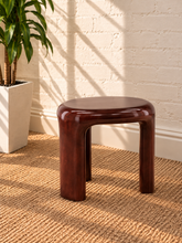 Load image into Gallery viewer, Image 4 of 5: Klarisse sculptural side table in chestnut high-gloss concrete with a rounded top and three curved integrated legs.