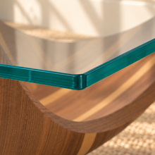 Load image into Gallery viewer, Laurel square coffee table with a clear tempered glass top and sculptural walnut veneer pedestal base featuring natural wood grain variation.