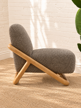 Load image into Gallery viewer, Lucia lounge chair with textured mocha upholstery, rounded seat and back, and sculptural curved natural wood sled frame