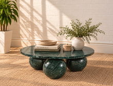 Load image into Gallery viewer, Martha round Forest Night marble coffee table with three spherical ball-shaped bases and natural dark green stone veining.