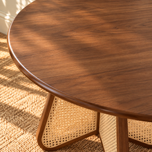 Load image into Gallery viewer, Nabi round dining table in Natural Brown with walnut finish and sculptural natural cane-inset pedestal base.