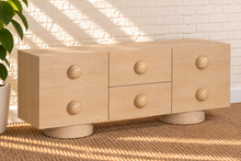 Load image into Gallery viewer, Norris Blonde Oak buffet credenza with oversized orb knobs, central drawers, cabinet storage, and rounded pedestal base