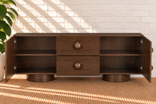 Load image into Gallery viewer, Norris Warm Walnut buffet credenza with oversized orb knobs, central drawers, cabinet storage, and sculptural pedestal base