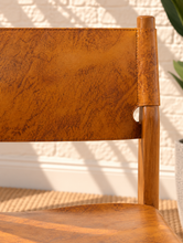 Load image into Gallery viewer, Nova counter stool in natural brown genuine leather with a tall teak wood frame, leather seat and backrest, footrest, and buckle strap detail.