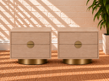 Load image into Gallery viewer, Pair of Jimena two-drawer nightstands in blonde oak with brushed brass metal bases and handles.
