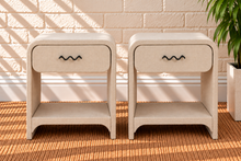 Load image into Gallery viewer, Pair of Thiago Greige linen-textured nightstands with rounded frames, drawers, matte black wave handles, and open lower shelves.