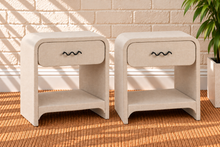 Load image into Gallery viewer, Pair of Thiago Greige linen-textured nightstands with rounded frames, drawers, matte black wave handles, and open lower shelves.