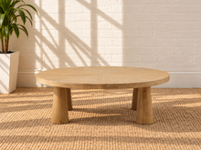 Load image into Gallery viewer, Rae coffee table in natural mango wood with a wide oval tabletop, rounded edges, and sculptural pedestal-style base.