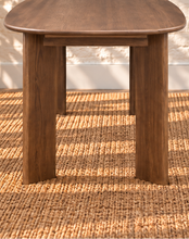 Load image into Gallery viewer, Rohan 79-inch oval dining table in dark walnut solid Mindi wood with rounded tabletop edges and architectural panel legs.