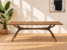 Load image into Gallery viewer, Image 2 of 4: Rubio 79-inch rectangular dining table in Natural Walnut with curved saber-leg trestle base and wood-look tabletop