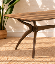 Load image into Gallery viewer, Image 4 of 4: Rubio 79-inch rectangular dining table in Natural Walnut with curved saber-leg trestle base and wood-look tabletop