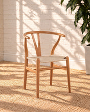 Load image into Gallery viewer, Sculptural blonde tone dining chair with curved wood back, central cutout splat and natural woven cord seat.