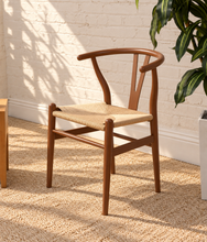 Load image into Gallery viewer, Sculptural walnut-tone dining chair with curved open back, central wood splat and natural woven cord seat.