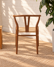 Load image into Gallery viewer, Sculptural walnut-tone dining chair with curved open back, central wood splat and natural woven cord seat.
