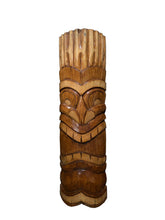 Load image into Gallery viewer, A carved wooden tiki mask statue with natural wood grain, standing upright against a dark textured background.
