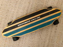 Load image into Gallery viewer, A vintage Kryptonics skateboard with a teal and light wood striped deck, resting on a beige carpet. The deck features black grip tape with white lettering that reads 'KRYPTONICS SINCE 1965'.