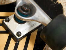 Load image into Gallery viewer, Close-up of a skateboard deck and truck assembly showing a black and white Nutronics truck base with a black wheel attached.