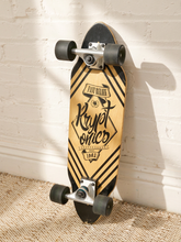 Load image into Gallery viewer, A longboard skateboard with a light wood deck featuring black graphic stripes and the text 'Krypt omics' and 'Fast Reload', resting against a white brick wall on a beige woven rug.